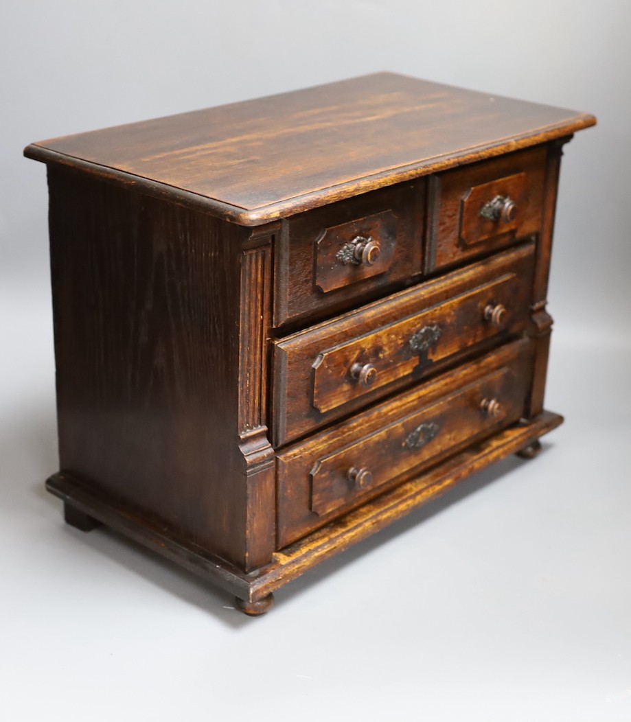 A 19th century miniature oak chest of drawers, 40 cms wide.